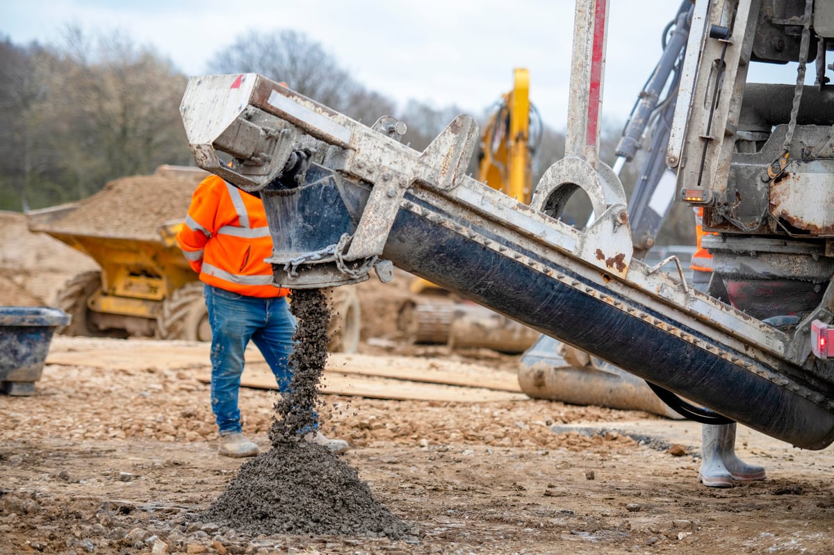 Workers pouring concrete from a truck in a rural area
